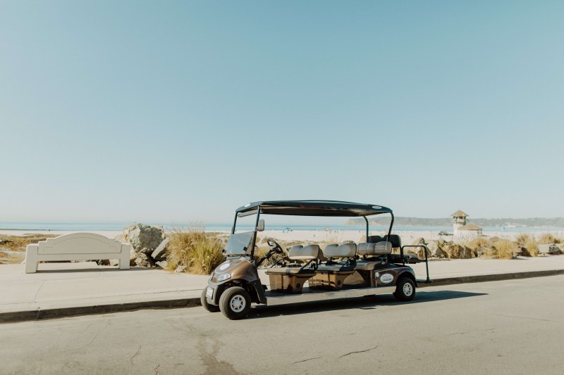 8 Passenger Golf Cart – Hourly Rental Image 1 a truck is parked on the side of a road