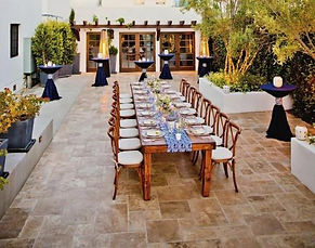 a group of people sitting at a table in a garden