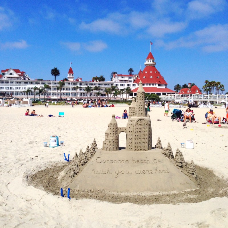 a group of people standing on top of a sandy beach