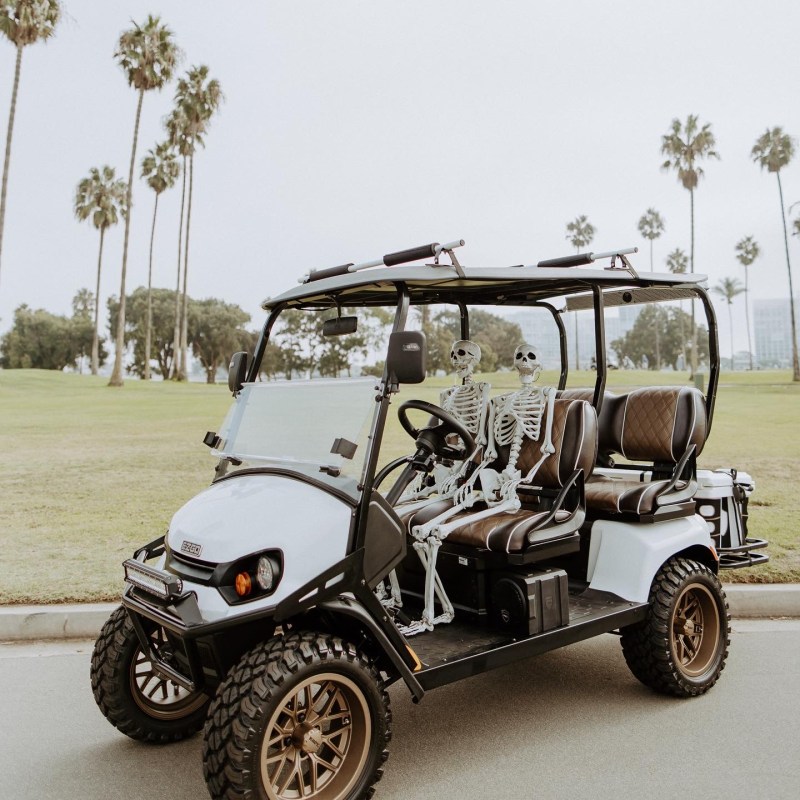 a man riding on the back of a truck driving down a dirt road