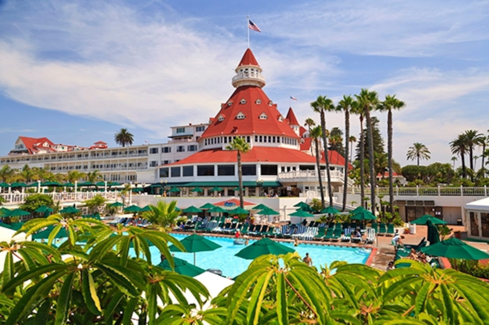 a large building with a green umbrella with Hotel del Coronado in the background